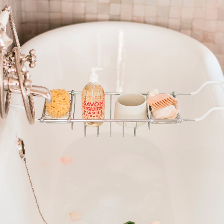 Compagnie de Provence Liquid Marseille Soap 495 ml fransk flytande rosentvål i en badkarshylla över ett badkar.