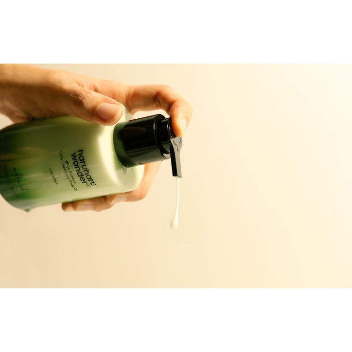 haruharu wonder Black Bamboo Daily Smoothing Body Oil 200 ml återfuktande kroppsvård där en vit droppe pumpas ur grön flaska