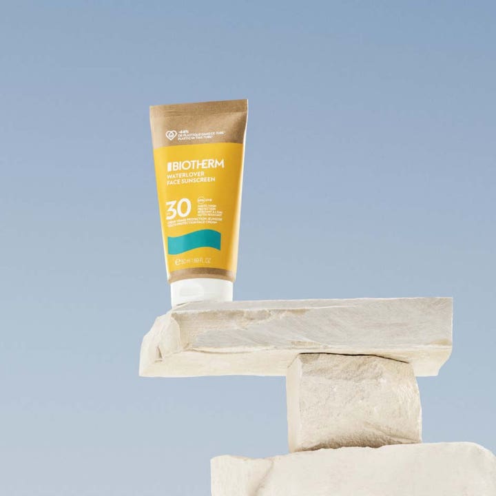 Biotherm Waterlover Face Cream SPF30 50 ml miljövänlig solkräm ansikte i gul tub på ljusa stenar mot blå himmel