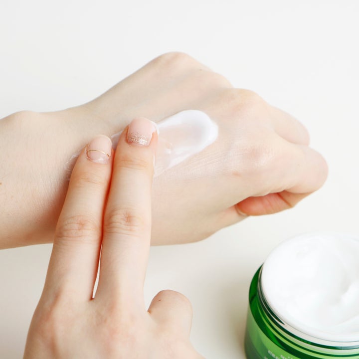 Dr. Ceuracle Tea Tree Purifine Cream 50 g lugnande ansiktskräm med vit krämig konsistens som smörjs ut från en grön burk.