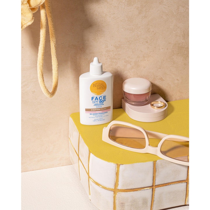 Bondi Sands SPF50+ Everyday Tinted Face Fluid 50 ml tonad solkräm ansikte i vit flaska bredvid somriga solglasögon