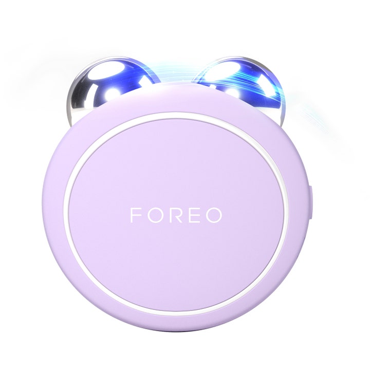 FOREO BEAR 2 go ansiktsapparat ger fastare hud med mikroström i en ljuslila rund form med två silvriga kulor