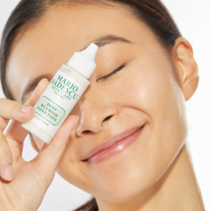 Mario Badescu Deep Blemish Solution 29 ml aknebehandling som hålls av en kvinna mot ansiktet