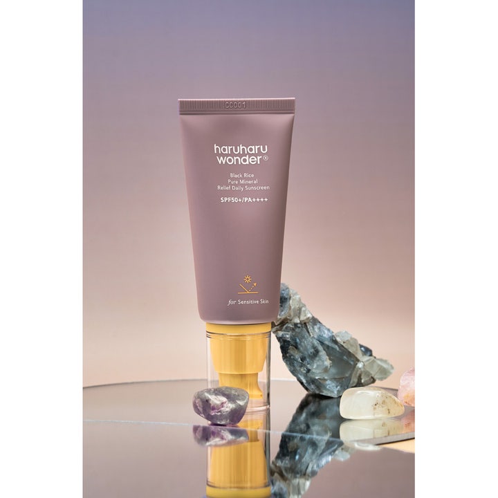 haruharu wonder Black Rice Sunscreen 50 ml mineral sunscreen för känslig hud i lila tub med gul pump bland stenar