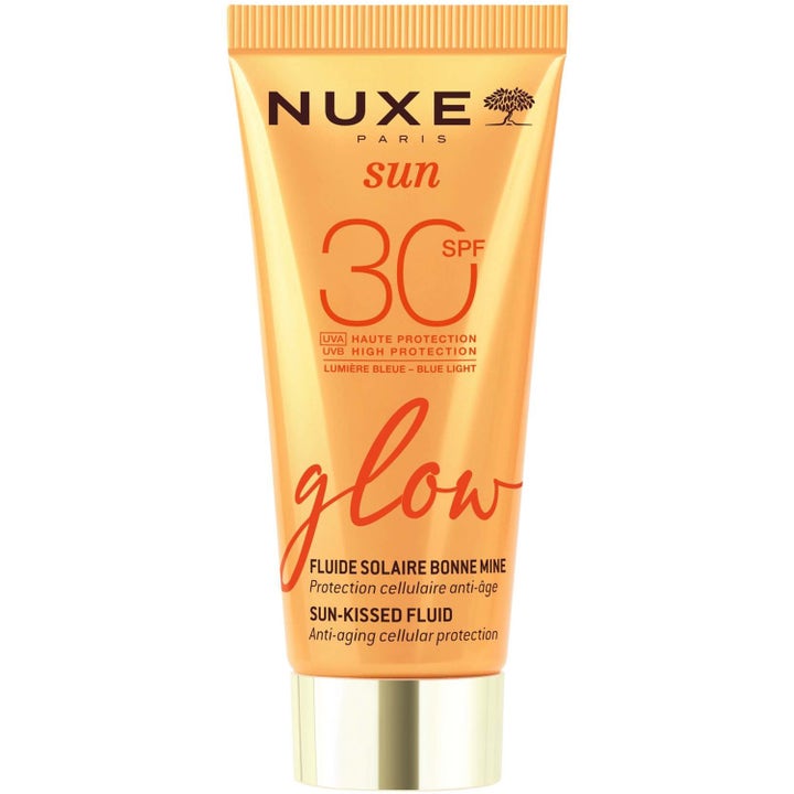 Nuxe Sun Glow Sun-Kissed Fluid SPF 30 ansiktsfluid ger lyster och anti-age skydd i en orange tub med guldlock.