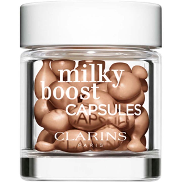Clarins Milky Boost Capsules lystergivande foundation i en genomskinlig glasburk med vitt lock och beige kapslar.