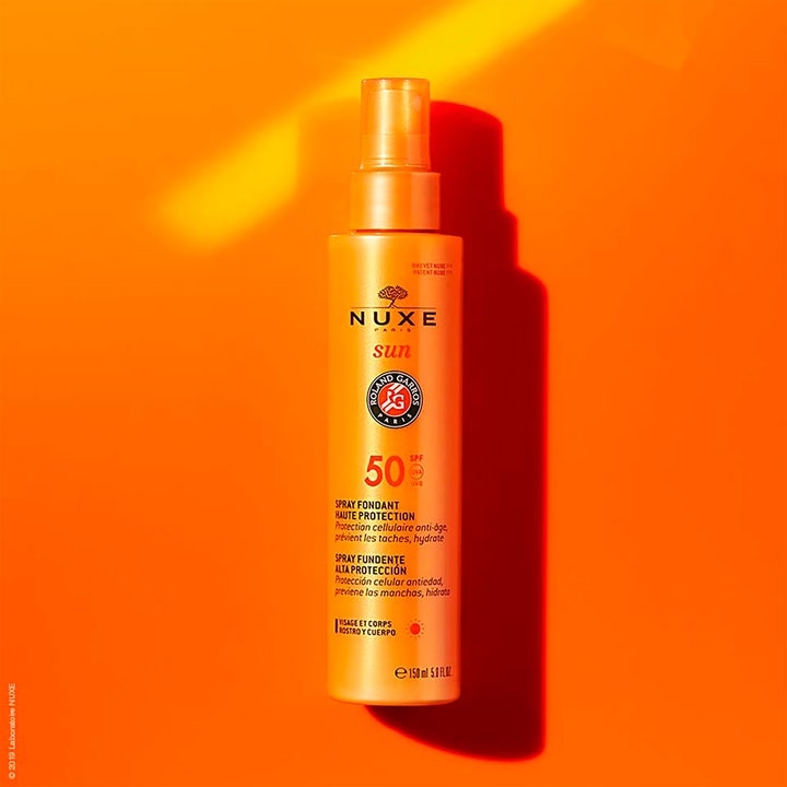 Nuxe Sun Face and Body Milk 184 g återfuktande solskyddsmedel SPF 50 i orange sprayflaska med Roland Garros-logo.