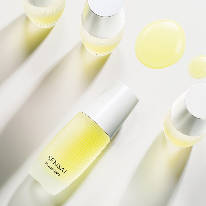Sensai Dual Essence 30 ml anti age dual behandling ger ansiktsglöd med gula oljedroppar bredvid frostade glasflaskor