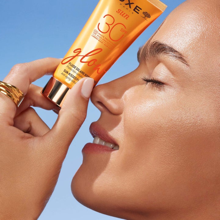 Nuxe Sun-Kissed Fluid Spf 30 40 ml ger lyster i ansiktet på kvinna med glowy hud och solkysst finish.