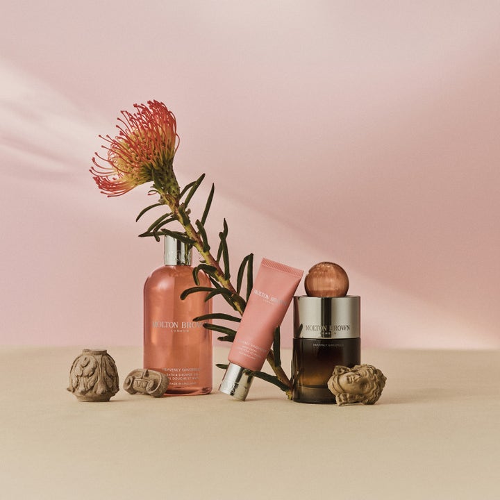 Molton Brown Heavenly Gingerlily Hand Cream 40 ml exklusiv handkräm i rosa tub bredvid en vacker exotisk blomma.