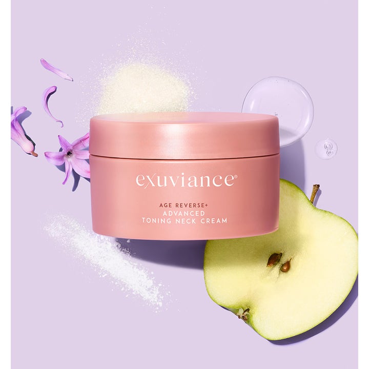 Exuviance Age Reverse Toning Neck Cream 125 g stärkande halskräm i rosa burk omgiven av äpple och lila blomblad