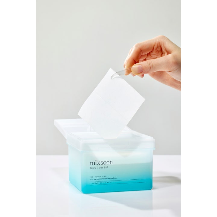 Mixsoon Bifida Toner Pad 120 st ansiktsvård toner pads som lyfts ur en blåtonad burk med en pincett.