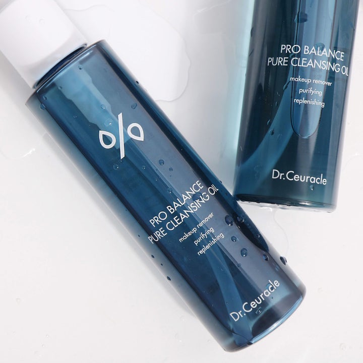 Dr. Ceuracle Pro Balance Pure Cleansing Oil 155 ml renande ansiktsrengöring i blå flaskor täckta av vattendroppar.
