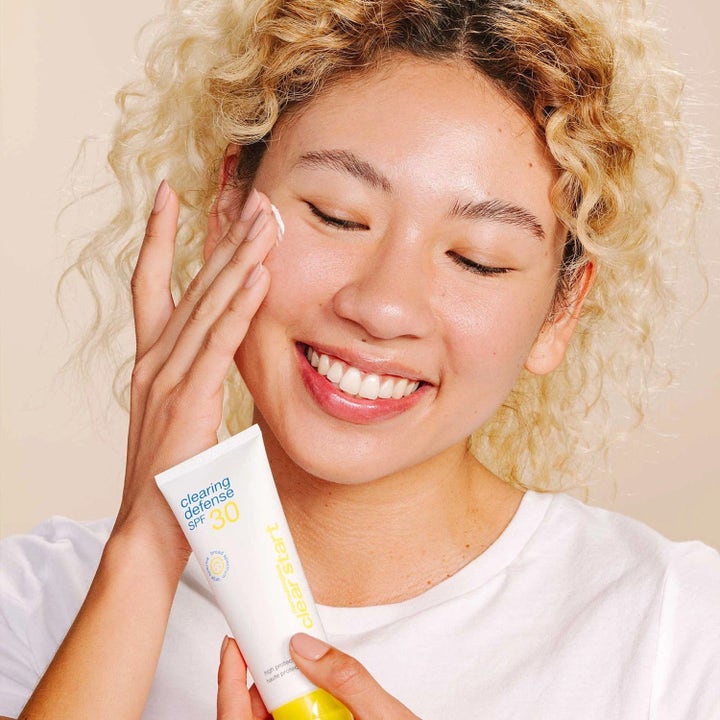 Dermalogica Clear Start Clearing Defense SPF30 hudvård där en person applicerar vit ansiktskräm från en tub med gul text