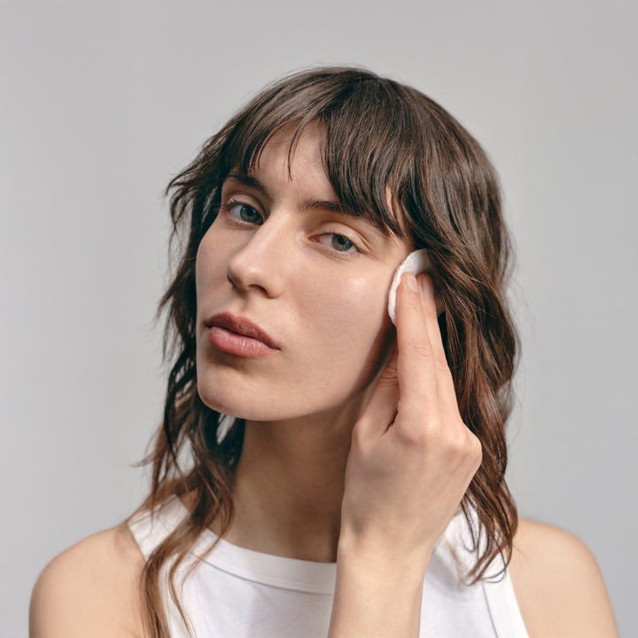 Jorgobé BHA Exfoliator 150 ml salicylsyra peeling som en kvinna applicerar i ansiktet med en bomullsrondell.