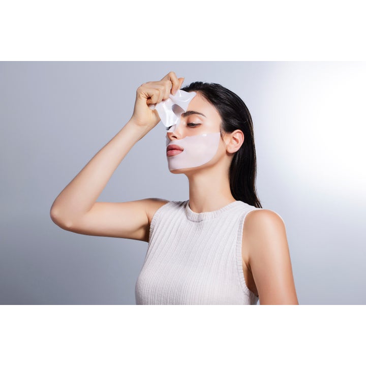 COSRX Advanced Snail Mucin Power Activating Hydrogel Mask 3 st återfuktande ansiktsmask med snigelslem applicerad på en kvinna