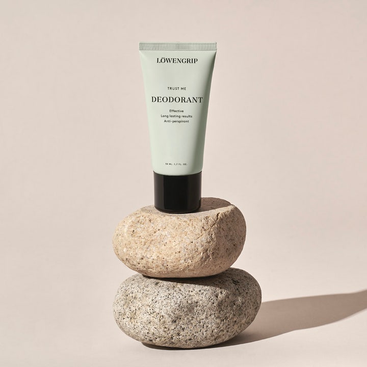 Löwengrip Trust Me Deodorant 50 ml antiperspirant i mintgrön tub placerad på staplade runda naturstenar.