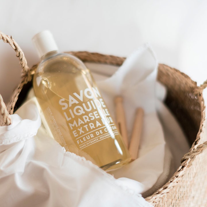 Compagnie de Provence Liquid Marseille Soap 1000 ml flytande tvål refill bomull i en flätad korg med vitt tyg.