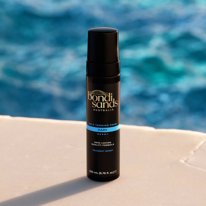 Bondi Sands Self Tanning Foam Dark 200 ml brun utan sol mousse med kokosdoft i svart flaska vid en pool