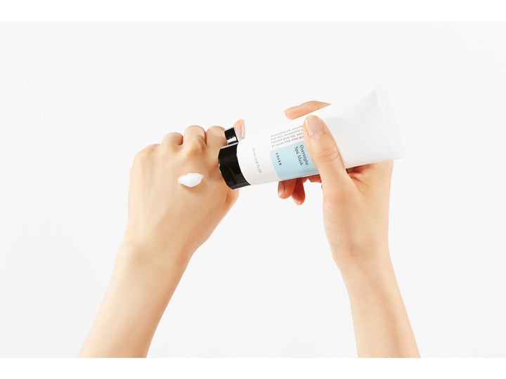 COSRX Ultimate Nourishing Rice Overnight Spa Mask 60 ml är en återfuktande ansiktsmask vit kräm på en hand