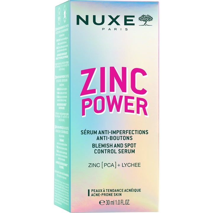 Nuxe Zinc Power Blemish And Spot Control Serum 30 ml mot orenheter i en iriserande kartong med rosa text.