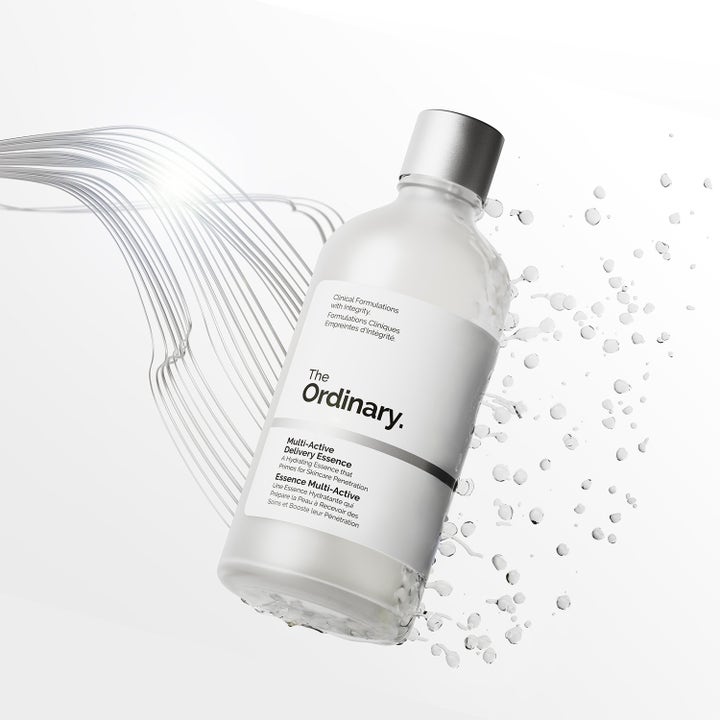 The Ordinary Multi-Active Delivery Essence 100 ml återfuktande primer omgiven av svävande vattendroppar.