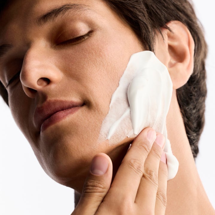Nuxe Men Shaving Foam 150 ml rakskum som ger en mjuk rakning applicerat som ett vitt fylligt skum på en mans kind
