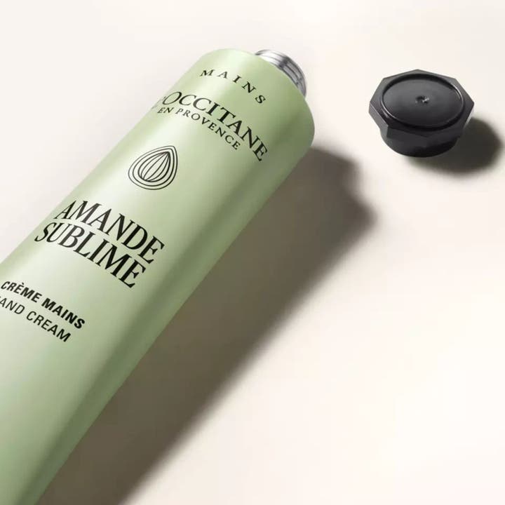 L'Occitane en Provence Almond Delicious Hands 75 ml återfuktande handkräm i ljusgrön tub med svart lock vid sidan.