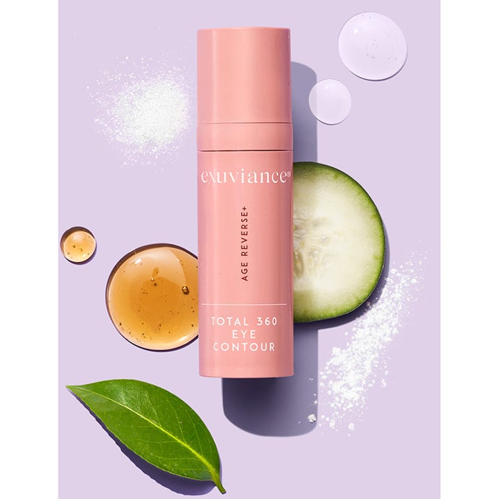 Exuviance Age Reverse Eye Contour 15 g uppstramande ögonkräm i rosa flaska omgiven av gurka och serumdroppar