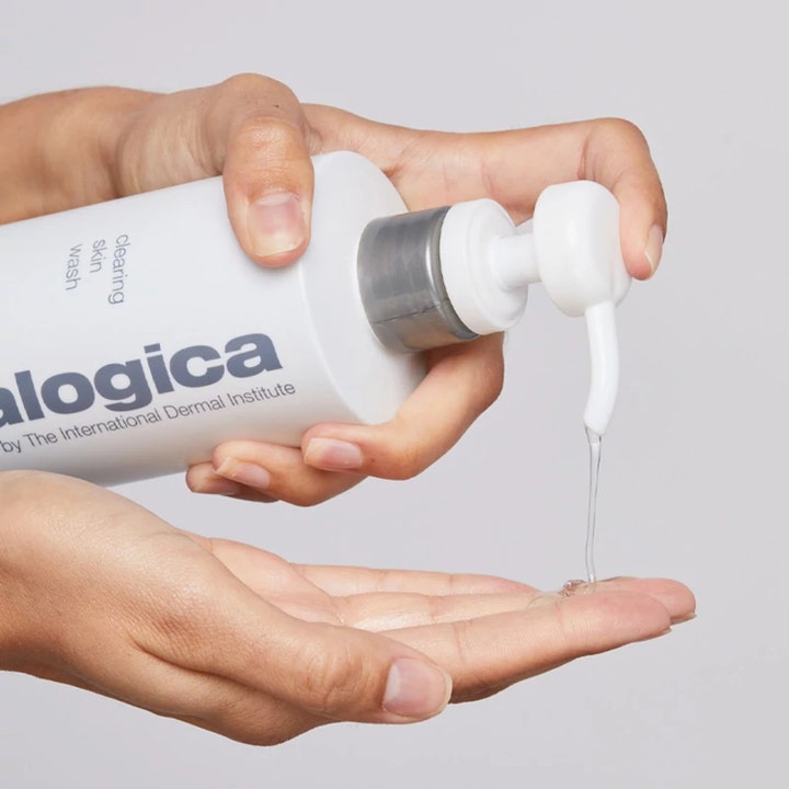 Dermalogica Clearing Skin Wash 250 ml porrensande rengöringsgel doseras som en klar gel från en vit pumpflaska i handen.