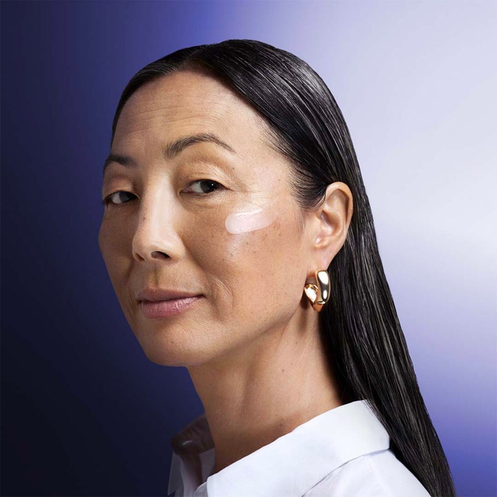 Shiseido Vital Perfection Overnight Firming Treatment 80 ml återfuktande nattkräm för fastare hud på en kvinnas kind
