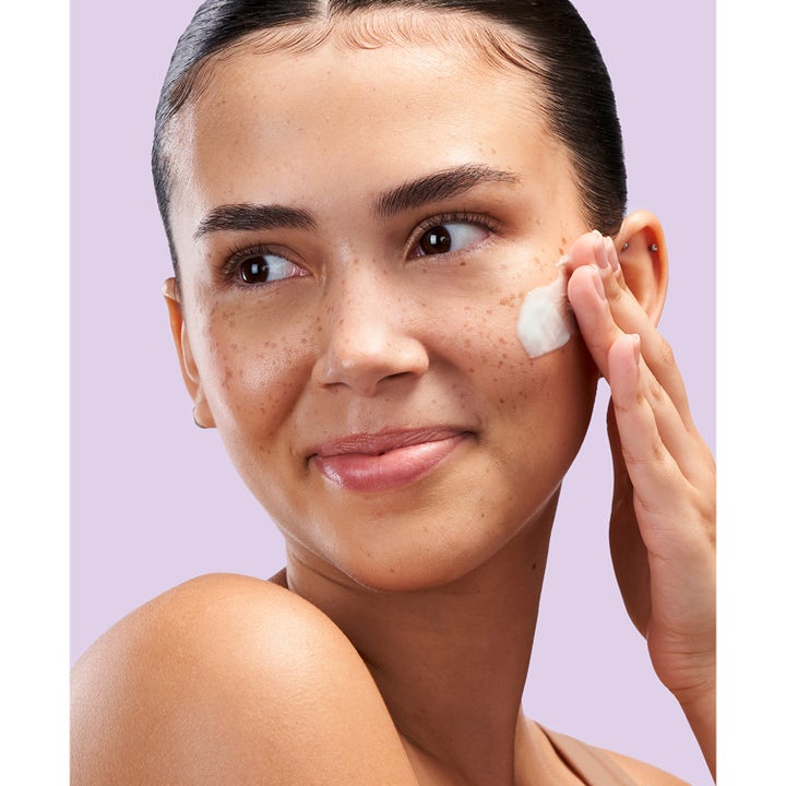 Exuviance Pro-Plump Hydrating Cream 45 g återfuktande nattkräm som appliceras av en kvinna på kinden.