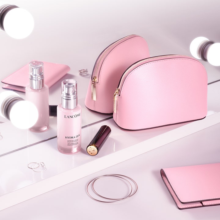 Lancôme Hydra Zen Liquid Moisturizer 50 ml återfuktande dagkräm i glasflaska bredvid rosa necessärer på ett sminkbord