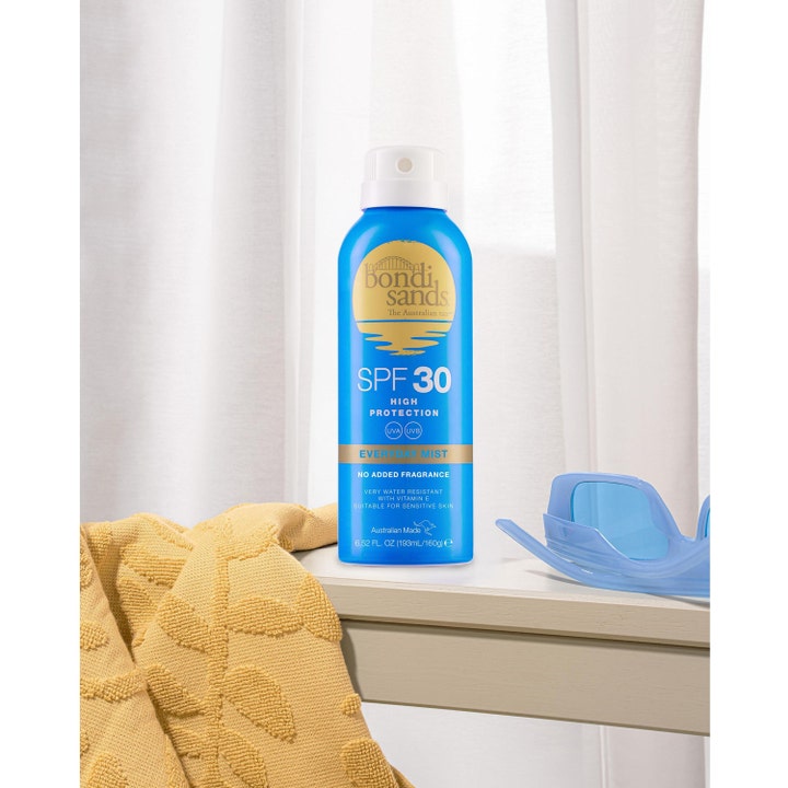 Bondi Sands SPF30 Everyday Aerosol Mist Spray 160 g blå spf 30 spray i miljö med gul handduk och solglasögon.
