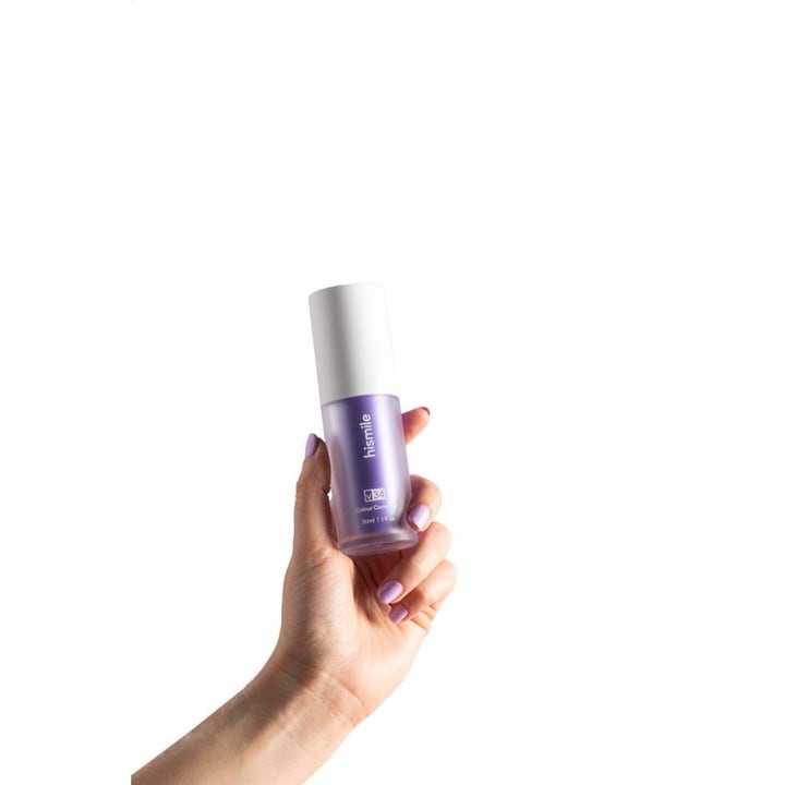Hismile Colour Corrector 30 ml tandblekning och färgkorrigerare i lila flaska som hålls av en hand med lila naglar