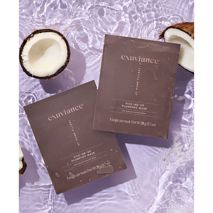 Exuviance Pick-Me-Up Plumping Mask 20 g sheet mask med hyaluronsyra i bruna påsar på vattenyta med kokosnötter.