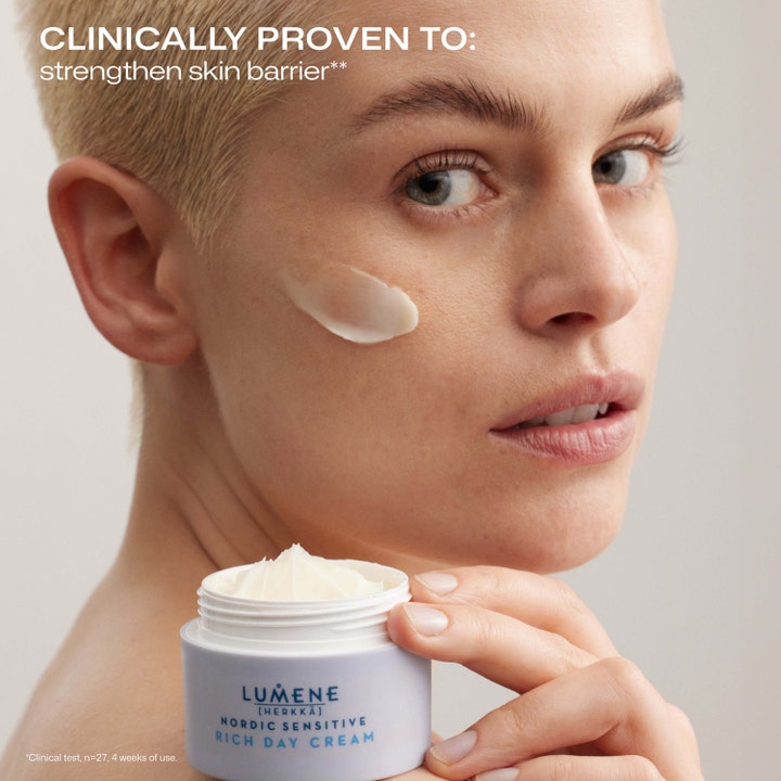 Lumene Nordic Sensitive Rich Day Cream 50 ml lugnande återfuktande dagkräm applicerad på kinden från en ljusblå burk.