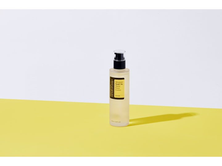 COSRX Advanced Snail 96 Mucin Power Essence 100 ml hudreparation essence i en transparent pumpflaska på gul bakgrund