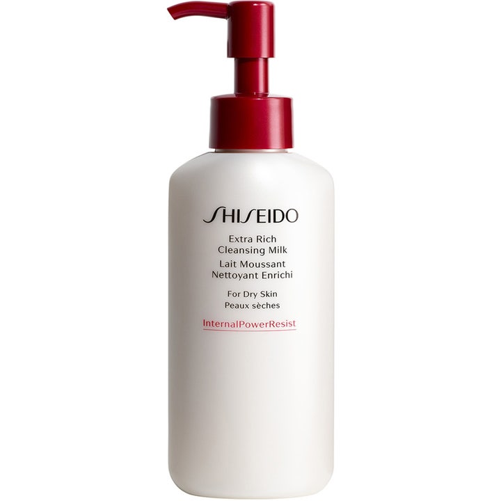Shiseido Extra Rich Cleansing Milk extra rik rengöringsmjölk för torr hy i en vit flaska med röd pump som ger hydrering.