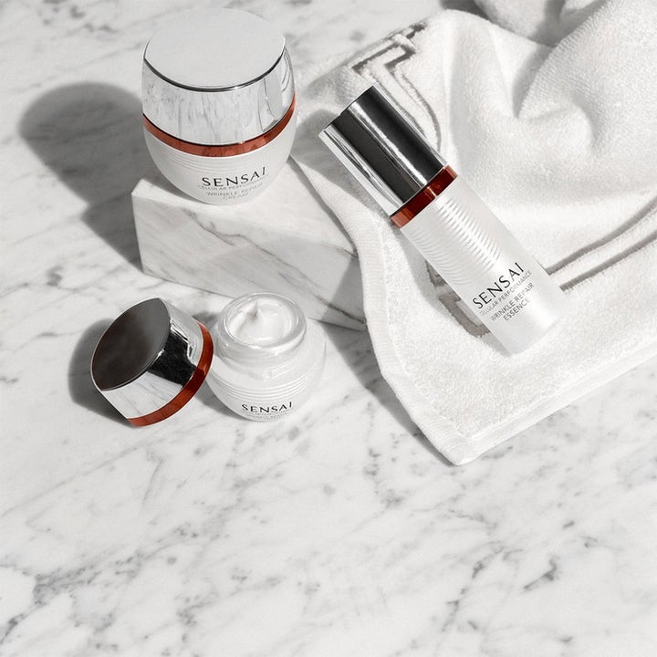 Sensai Cellular Performance Wrinkle Repair set ger anti-rynk hudföryngring med kräm och essence på vit marmoryta.