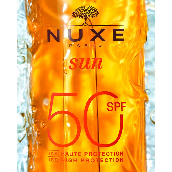 Nuxe Tanning Sun Oil 150 ml sololja med SPF 50 ger högt skydd i en bärnstensfärgad flaska täckt av vattenstänk.