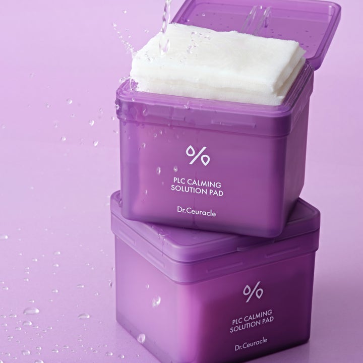 Dr. Ceuracle PLC Calming Solution Pad 130 st toner i lila burkar med vita pads och vattenstänk.