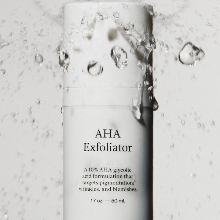 Jorgobé AHA Exfoliator 50 ml 10% glykolsyra peeling i vit flaska omgiven av dramatiska vattenstänk