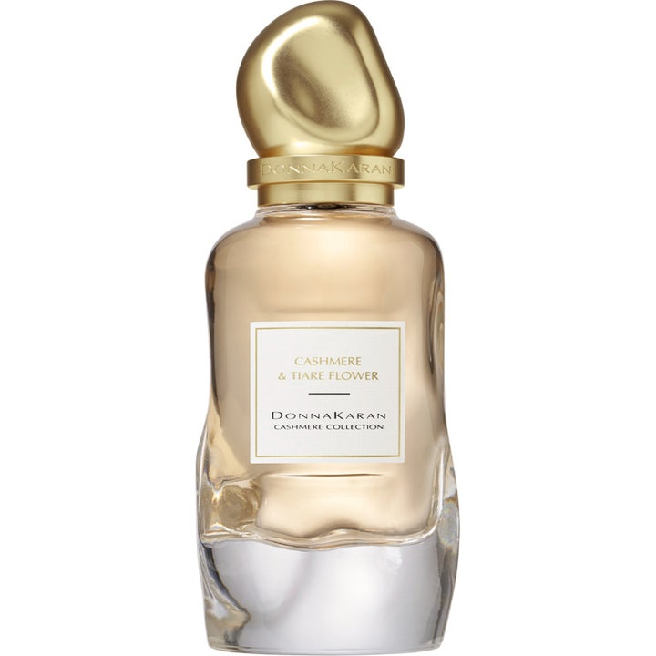 DKNY Cashmere Collection Tiare Flower Eau De Parfum 100 ml i en vågig glasflaska med ett skulpturalt guldfärgat lock