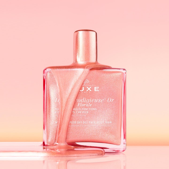 Nuxe Huile Prodigieuse Gold Florale 151 g roséguld olja i glasflaska med rinnande skimrande textur som ger ansiktsglöd.