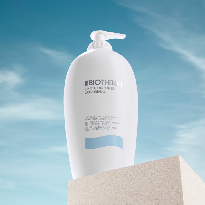 Biotherm Lait Corporel 400 ml anti-uttorkande kroppsmjölk i vit pumpflaska placerad mot en blå himmel