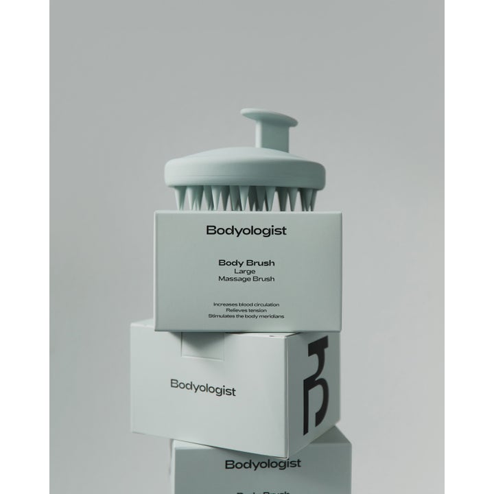 Bodyologist Body Brush 1 st stimulerande massageborste placerad på trave av ljusgröna förpackningar