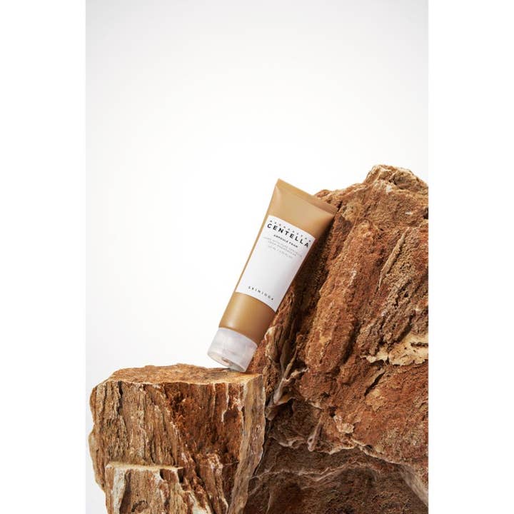 SKIN1004 Madagascar Centella Ampoule Foam 125 ml lugnande ansiktsrengöring skum känslig hud i brun tub mot sten