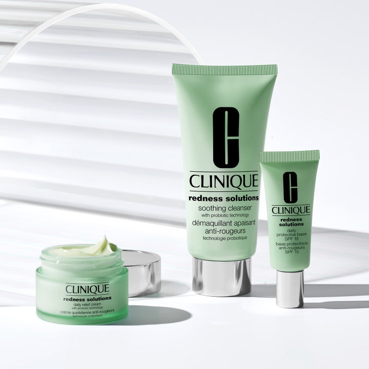 Clinique Redness Solutions 50 ml lugnande rodnadskräm i öppen grön glasburk bredvid rengöring och SPF-bas