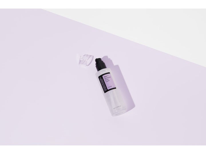 COSRX AHA 7 Whitehead Power Liquid 100 ml aha exfoliering ansiktsvatten i frostad pumpflaska på ljuslila bakgrund.